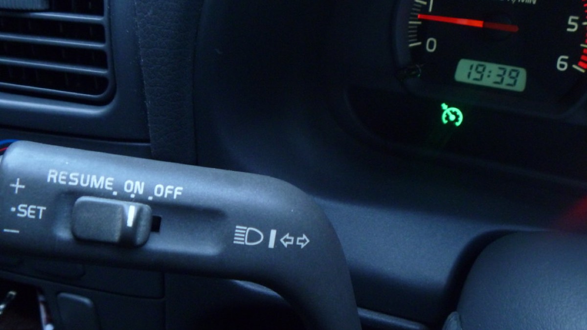 A car's dashboard and tachometer seen from the driver's seat while under way.